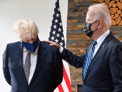 TOPSHOT - Britain's Prime Minister Boris Johnson (L) and US President Joe Biden, wearing face coverings due to Covid-19, view documents relating to the Atlantic Charter prior to a bi-lateral meeting at Carbis Bay, Cornwall on June 10, 2021, ahead of the three-day G7 summit being held from 11-13 June. …