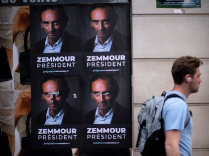 A passer-by walks past placards displayed by support committee memmbers, depicting France's far right ideologue Eric Zemmour in a Paris street, on June 28, 2021. (Photo by Olivier MORIN / AFP) (Photo by OLIVIER MORIN/AFP via Getty Images)