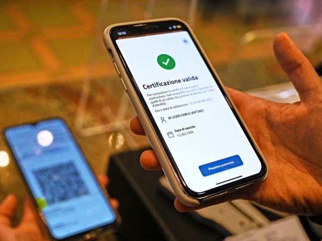 A bar owner uses the VerifyC19 mobile phone application to scan a Green Pass in central Rome on August 6, 2021, as Italy made the Green Pass, which is an extension of the EU's digital Covid certificate, required from today to enter cinemas, museums and indoor sports venues, or eat …