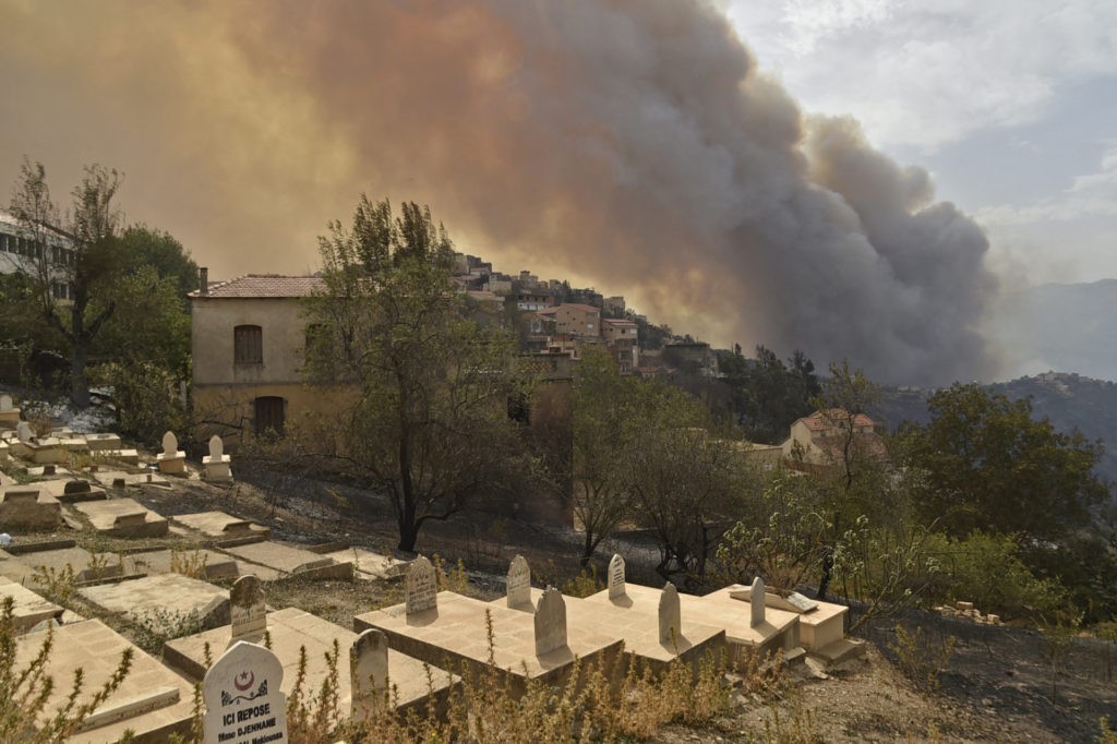 Smoke billows from a wildfire in the forested hills of the Kabylie region, east of the capital Algiers, on August 10, 2021. - Wildfires fanned by blistering temperatures and tinder-dry conditions have killed at least seven people in Algeria, the interior minister said, adding the fires had criminal origins. (Photo by Ryad KRAMDI / AFP) (Photo by RYAD KRAMDI/AFP via Getty Images)