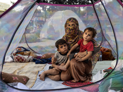 KABUL, AFGHANISTAN - AUGUST 12: Farzia, 28, who lost her husband in Baghlan one week ago to fighting by the Taliban sits with her children, Subhan, 5, and Ismael ,2, in a tent at a makeshift IDP camp in Share-e-Naw park to various mosques and schools on August 12, 2021 …