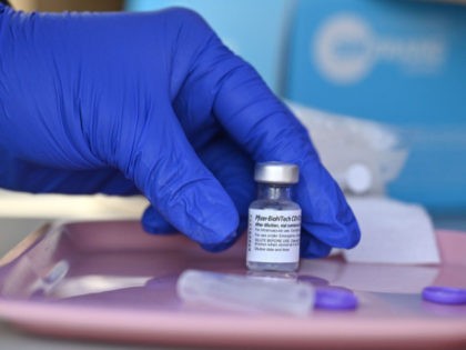 A nurse reaches for a vial of Pfizer-BioNTech Covid-19 vaccine at a pop up vaccine clinic in the Arleta neighborhood of Los Angeles, California, August 23, 2021. - The US Food and Drug Administration on August 23, fully approved the Pfizer-BioNTech Covid shot, triggering a new wave of vaccine mandates …