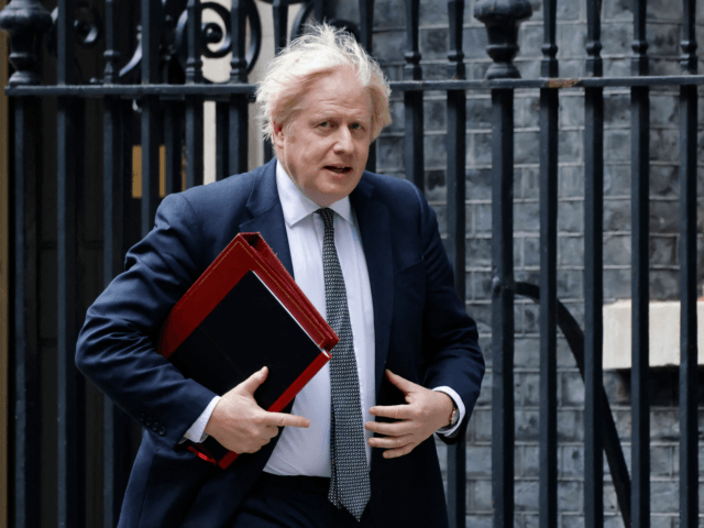 Britain's Prime Minister Boris Johnson walks from 10 Downing Street to the press briefing
