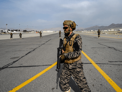 Members of the Taliban Badri 313 military unit walks at the tarmac as they secure the airp