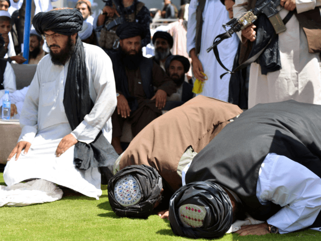 Taliban supporters pray during a gathering to celebrate the US withdrawal of all its troop