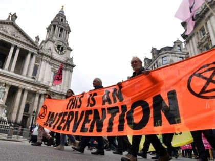 Climate activists from the Extinction Rebellion group walk past St Paul's cathedral in central London on September 2, 2021 during the group's 'Impossible Rebellion' series of actions. - Climate change demonstrators from environmental activist group Extinction Rebellion continued with their latest round of protests in central London, promising two weeks …
