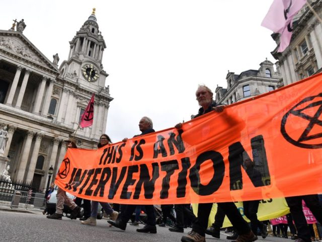 Climate activists from the Extinction Rebellion group walk past St Paul's cathedral in central London on September 2, 2021 during the group's 'Impossible Rebellion' series of actions. - Climate change demonstrators from environmental activist group Extinction Rebellion continued with their latest round of protests in central London, promising two weeks …