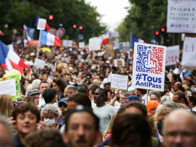 People hold placards and wave French national flags as they march during a demonstration to protest against the mandatory Covid-19 health pass to access most of the public space, in Paris on September 4, 2021. (Photo by Stefano RELLANDINI / AFP) (Photo by STEFANO RELLANDINI/AFP via Getty Images)
