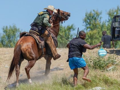 A United States Border Patrol agent on horseback uses the reins to try and stop a Haitian migrant from entering an encampment on the banks of the Rio Grande near the Acuna Del Rio International Bridge in Del Rio, Texas on September 19, 2021. - The United States said Saturday …