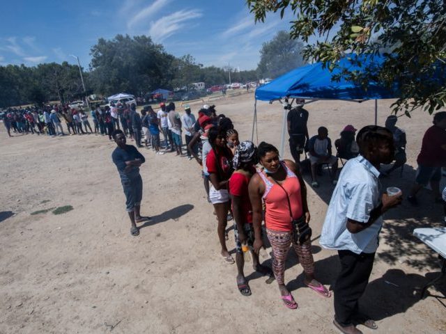 Haitian migrants queue to get food at a shelter in Ciudad Acuna, Coahuila state, Mexico, on September 21, 2021. - Mexican President Andres Manuel Lopez Obrador urged the United States on Wednesday to act quickly to tackle the causes of the migrant crisis affecting the two neighboring countries. "Enough talking, …