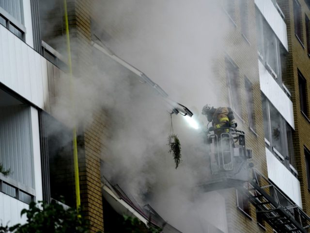 A fireman is seen working at the site of an explosion in central Gothenburg on September 28, 2021. - Some 20 people were taken to hospital after an explosion hit a residential building causing a fire affecting several appartments and stairwells in the south western Swedish city of Gothenburg early …