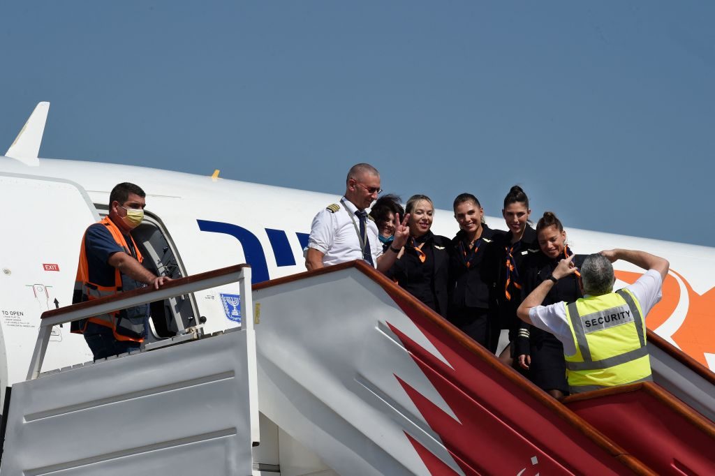 Crew members pose for a picture as they disembark from the plane taken by the Israeli Foreign Minister upon arrival at the Bahrain International Airport, on September 30, 2021. - Israel's Foreign Minister Yair Lapid began a landmark visit to Bahrain where he will open the Israeli embassy one year after the US-brokered normalisation of ties. (Photo by Mazen MAHDI / AFP) (Photo by MAZEN MAHDI/AFP via Getty Images)