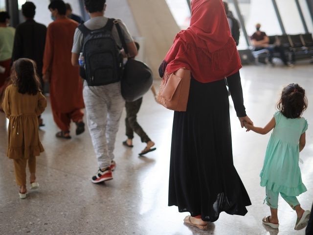 Refugees arrive at Dulles International Airport after being evacuated from Kabul following the Taliban takeover of Afghanistan August 27, 2021 in Dulles, Virginia. Refugees continued to arrive in the United States one day after twin suicide bombings at the gates of the airport in Kabul killed 13 U.S. military service …