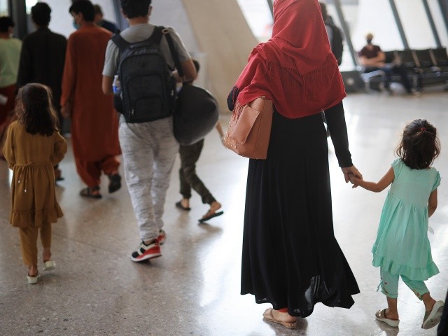 Refugees arrive at Dulles International Airport after being evacuated from Kabul following the Taliban takeover of Afghanistan August 27, 2021 in Dulles, Virginia.  Refugees continued to arrive in the United States one day after twin suicide bombings at the gates of the airport in Kabul killed 13 US military service members and nearly 100 Afghans.  