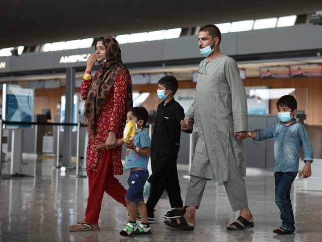 DULLES, VIRGINIA - AUGUST 31: Refugees are led through the departure terminal to a bus at Dulles International Airport after being evacuated from Kabul following the Taliban takeover of Afghanistan on August 31, 2021 in Dulles, Virginia. The Department of Defense announced yesterday that the U.S. military had completed its …