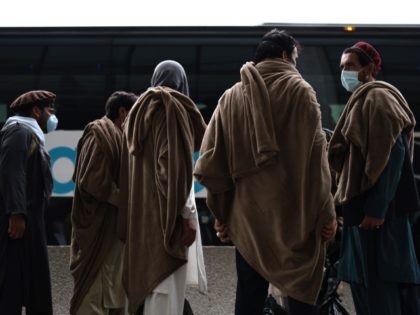 DULLES, VIRGINIA - AUGUST 31: Refugees board a bus at Dulles International Airport that will take them to a refugee processing center after being evacuated from Kabul following the Taliban takeover of Afghanistan on August 31, 2021 in Dulles, Virginia. The Department of Defense announced yesterday that the U.S. military …