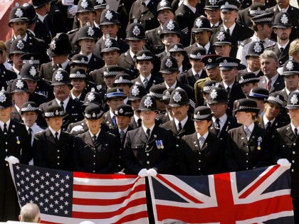 NEW YORK - SEPTEMBER 11: British police officers walk together carrying the American and British flags as they arrive at the Ground Zero site for the ceremony to mark the two-year anniversary of the attacks on the World Trade Center September 11, 2003 in New York City. (Photo by Mike …