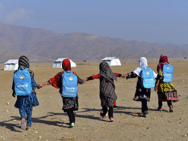 Afghan schoolgirls held their hand and walk through their tent classrooms on the outskirts