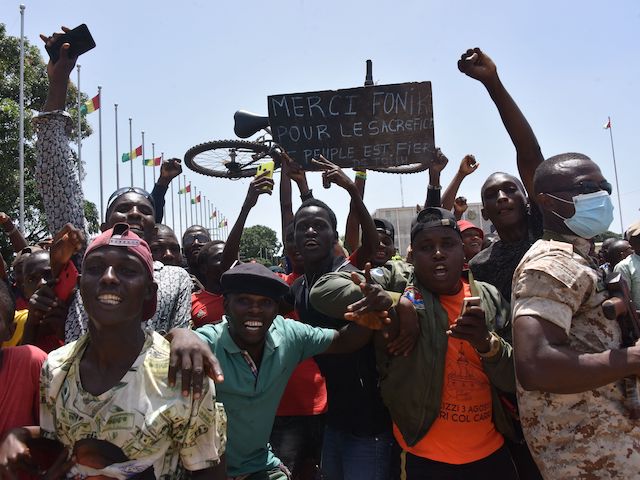 People celebrate as the Guinean Special Forces arrive at the Palace of the People in Conakry on September 6, 2021, ahead of a meeting with the Ministers of the Ex-President of Guinea, Alpha Conde. - Guinean special forces seized power in a coup on September 5, 2021 arresting the president Alpha Conde and imposing an indefinite curfew in the west African country."We have decided, after having taken the president, to dissolve the constitution," said a uniformed officer flanked by soldiers toting assault rifles in a video sent to AFP. (Photo by CELLOU BINANI / AFP) (Photo by CELLOU BINANI/AFP via Getty Images)