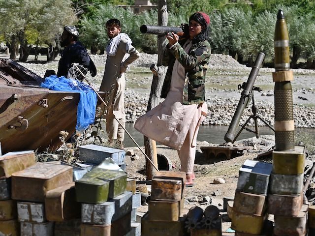 Taliban fighters stand next to ammunition along a road in Malaspa area, Bazark district, P