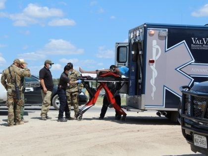 A local ambulance crew loads a woman from the Del Rio migrant camp into an ambulance. (Fil