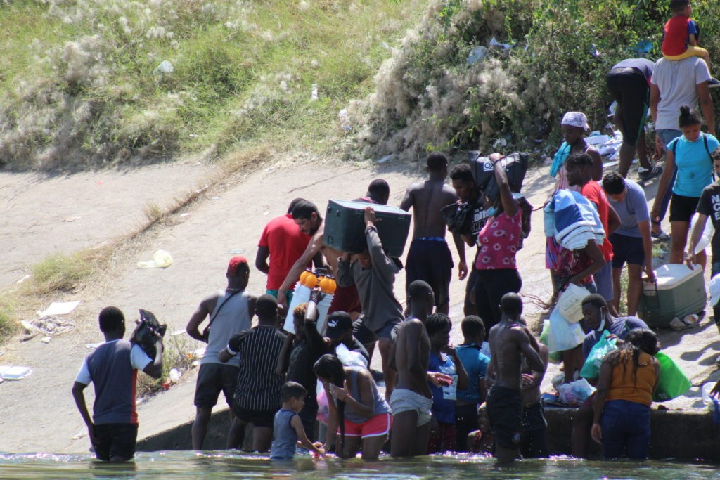 Hundreds of migrants stream across the Rio Grande near Del Rio. Many carried supplies from Mexico as the camp's population grew to nearly 15,000. (Photo: Randy Clark/Breitbart Texas)