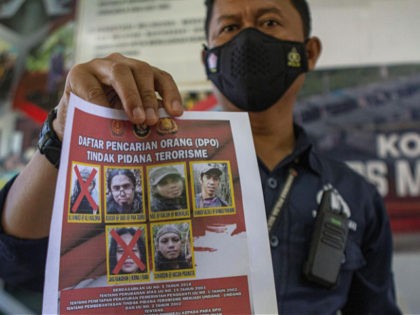 A police officer shows a wanted poster displaying the photos of two militants Ali Kalora, top left, and Jaka Ramadan, bottom left, who were killed during shootout with security forces, during a press conference at the Parigi Moutong Police Station in Parigi Moutong district, Central Sulawesi, Indonesia, Sunday, Sept. 19, …