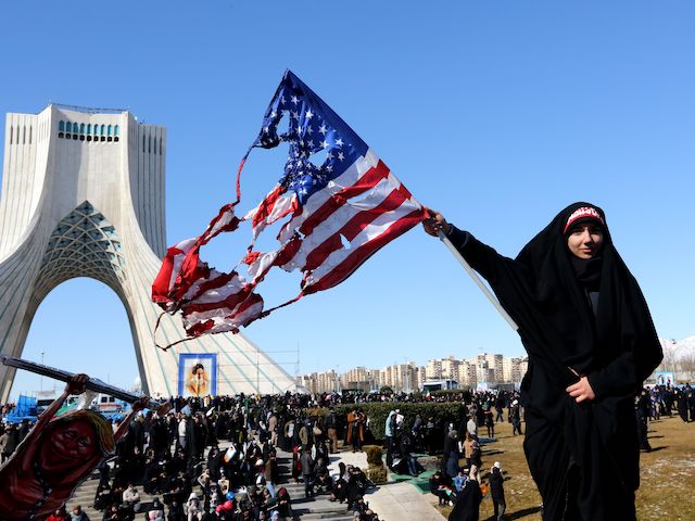 An Iranian woman waves a burnt US flag during commemorations marking 41 years since the Islamic Revolution in the capital Tehran's Azadi Square on February 11, 2020. (Atta Kenare/AFP via Getty Images)