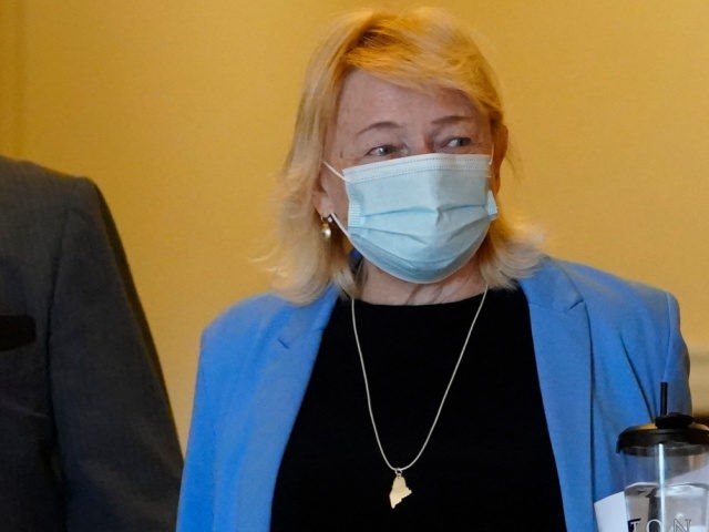 Gov. Janet Mills wears a face covering while walking through the halls of the State House,