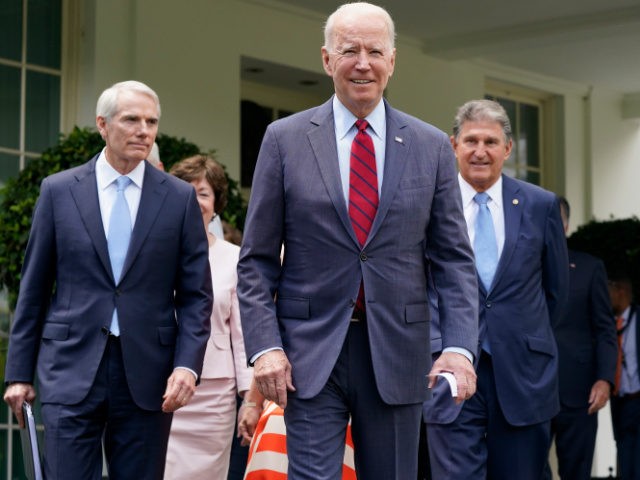 In this June 24, 2021, file photo President Joe Biden, flanked by Sen. Rob Portman (R-OH),