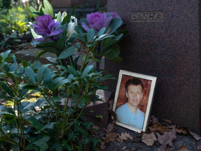 A photograph lies beside the gravestone of Russian ex-spy Alexander Litvinenko in Highgate Cemetery on December 1, 2020 in north London. - Global warming is threatening London's historic Highgate Cemetery, an overgrown oasis housing graves of notable figures from Karl Marx to pop singer George Michael, its custodians say. Concerned …