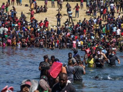 Haitian migrants, part of a group of over 10,000 people staying in an encampment on the US side of the border, cross the Rio Grande river to get food and water in Mexico, after another crossing point was closed near the Acuna Del Rio International Bridge in Del Rio, Texas …