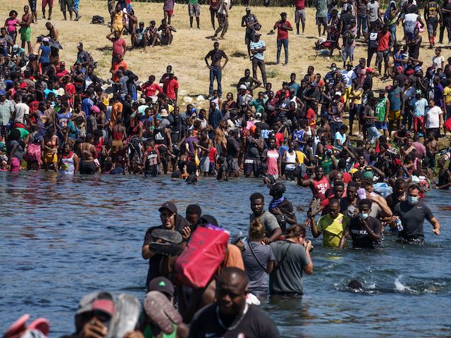 Haitian migrants, part of a group of over 10,000 people staying in an encampment on the US side of the border, cross the Rio Grande river to get food and water in Mexico, after another crossing point was closed near the Acuna Del Rio International Bridge in Del Rio, Texas on September 19, 2021. (Paul Ratje/AFP via Getty Images)