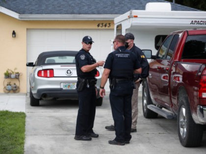 An FBI agent talks with a North Port officer while they collect evidence from the family home of Brian Laundrie, who is a person of interest after his fiancé Gabby Petito went missing on September 20, 2021 in North Port, Florida. A body has been found by authorities in Wyoming …