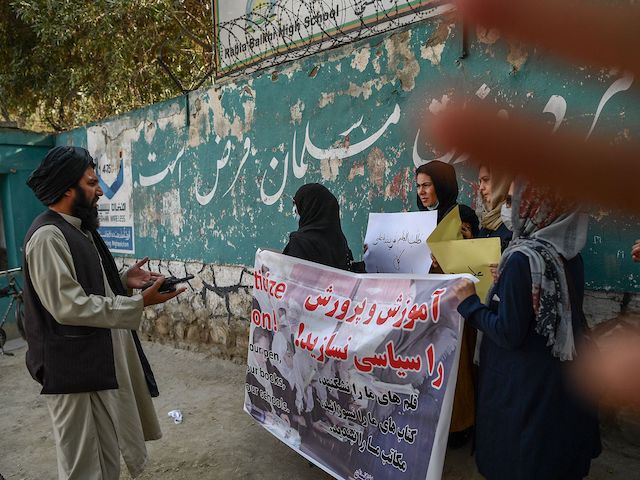 A member of the Taliban speaks with women protestors as another tries to block the view of the camera with his hand during a demonstration held outside a school in Kabul on September 30, 2021. (Bulent Kilic/AFP via Getty Images)