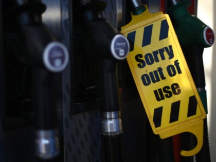 An out of use sign is attached to a pump at an Esso petrol station in east London on September 24, 2021. - The UK government today urged the public against panic-buying as some petrol stations closed pumps due to a lack of lorry drivers to deliver fuel. (Photo by …