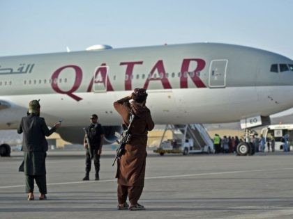 A Qatari security personnel (2L) and Taliban fighters stand guard as passengers board a Qatar Airways aircraft at the airport in Kabul on September 9, 2021. - Some 200 passengers, including US citizens, left Kabul airport on September 9, 2021, on the first flight carrying foreigners out of the Afghan …