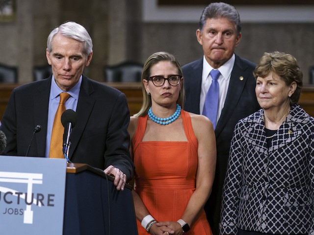 In this July 28, 2021 file photo, bipartisan Senate negotiators speak to reporters just after a vote to start work on a nearly $1 trillion infrastructure package, at the Capitol in Washington. From left are Sen. Rob Portman, R-Ohio, Sen. Kyrsten Sinema, D-Ariz., Sen. Joe Manchin, D-W.Va., and Sen. Jeanne Shaheen, D-N.H. Centrist Democrats Manchin and Sinema are vital to the fate of President Joe Biden's $3.5 trillion "Build Back Better" agenda. (AP Photo/J. Scott Applewhite, file)
