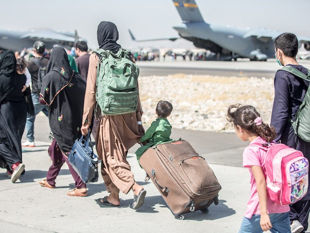 A child looks at the aircraft as he is strolled towards his flight during an evacuation at Hamid Karzai International Airport, Kabul, Afghanistan, Aug. 24. U.S. service members are assisting the Department of State with an orderly drawdown of designated personnel in Afghanistan. (U.S. Marine Corps photo by Sgt. Samuel …