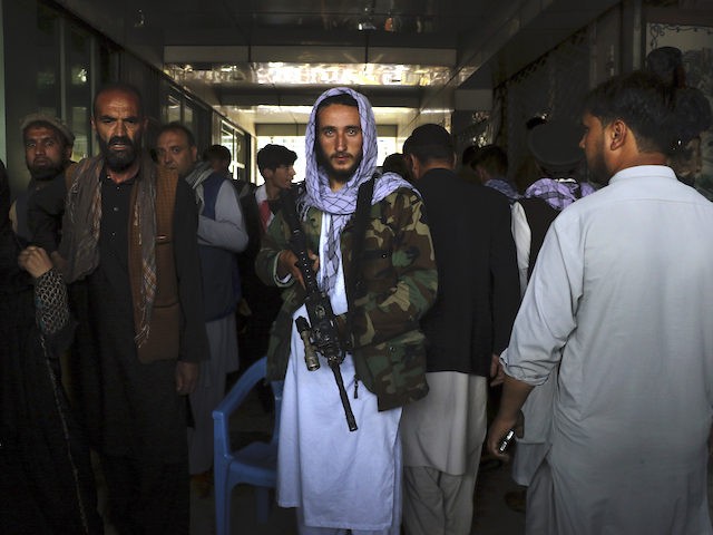 Taliban fighters stand guard bya black market currency exchange at Sarai Shahzada market i