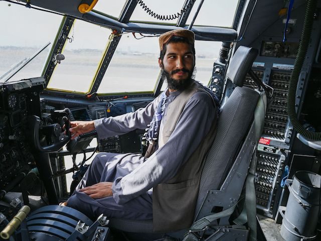 A Taliban fighter sits in the cockpit of an Afghan Air Force aircraft at the airport in Kabul on August 31, 2021.(Wakil Kohsar/AFP via Getty Images)