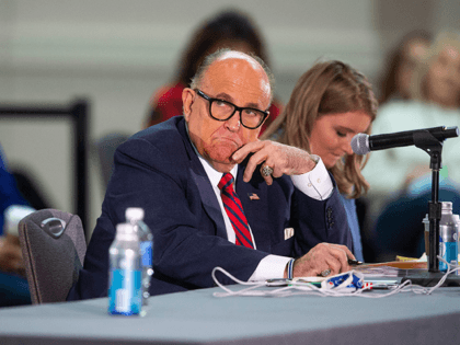 President Donald Trump's attorney Rudy Giuliani listens to presenters at a public meeting where Trump supporters disputed his defeat in the 2020 election, citing election fraud and other concerns, at the Hyatt Regency Hotel in Phoenix, Arizona, on Nov. 30, 2020.