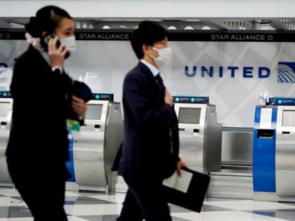 United Airlines employees wear mask as they walk through in Terminal 1 at O'Hare Inte