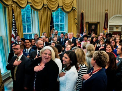 US President Donald Trump stands with teachers and others to say the pledge of allegiance during a national teacher of the year event in the Oval Office of the White House April 26, 2017 in Washington, DC. / AFP PHOTO / Brendan Smialowski (Photo credit should read BRENDAN SMIALOWSKI/AFP via …