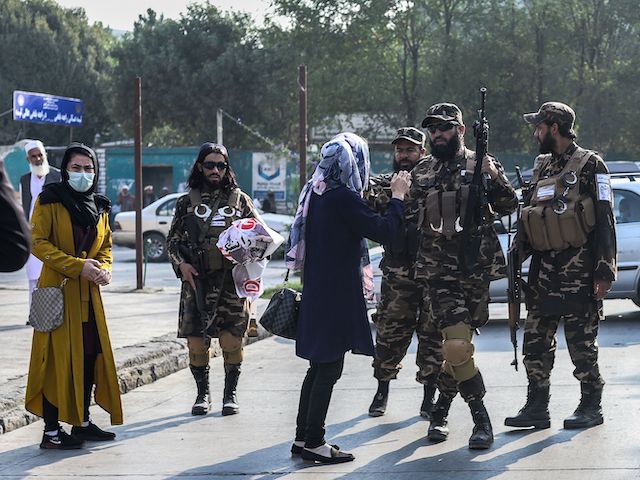 Members of the Taliban special forces stop a woman protestor from continuing a demonstration held outside a school in Kabul on September 30, 2021. (Bulent Kilic/AFP via Getty Images)