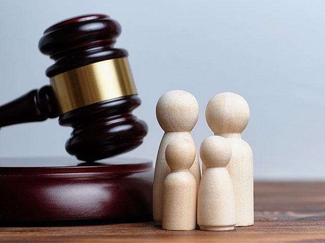 The concept of adopting children by a family. The hammer of a judge with abstract figures