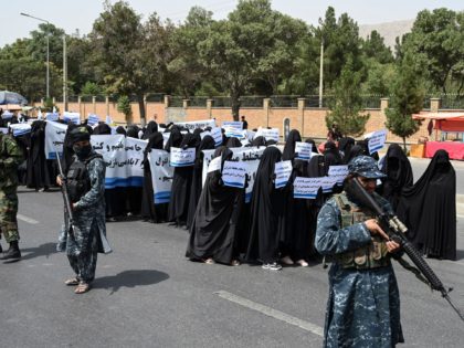 Armed Taliban fighters escort veiled women as they march during a pro-Taliban rally outside Shaheed Rabbani Education University in Kabul on September 11, 2021. (Photo by Aamir QURESHI / AFP) (Photo by AAMIR QURESHI/AFP via Getty Images)