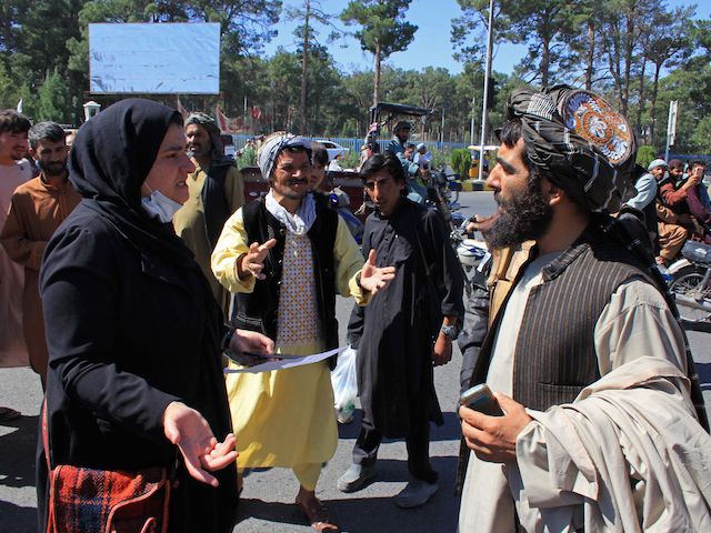 TOPSHOT - An Afghan woman protester (3L) speaks with a member (R) of the Taliban during a protest in Herat on September 2, 2021. - Defiant Afghan women held a rare protest on September 2 saying they were willing to accept the all-encompassing burqa if their daughters could still go to school under Taliban rule. (Photo by - / AFP) (Photo by -/AFP via Getty Images)
