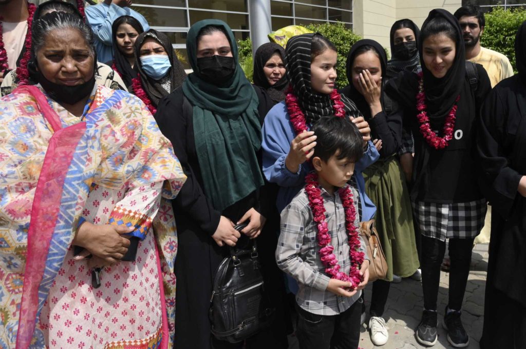 Members of Afghanistan's women soccer team and their families pose for a photograph after they were greeted by officials of the Pakistan Football Federation, in Lahore, Pakistan, Wednesday, Sept. 15, 2021. Officials and local media said Wednesday that an unspecified number of Afghan women players and their family members were allowed to enter in Pakistan after apparently fleeing their country for security reasons. (AP Photo/Waleed Ahmed)