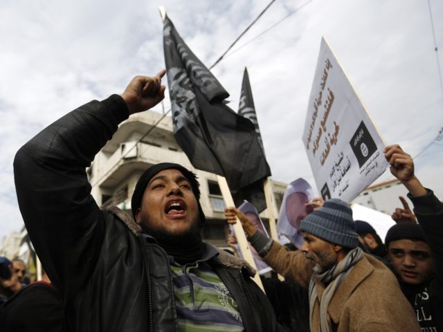 Palestinian Salafist Jihadists wave al-Qaeda-affiliated flags shouting slogans during a protest against the printing of satirical sketches of the Prophet Mohammed by French satirical weekly Charlie Hebdo on January 19, 2015 on their way to the French Cultural Centre in Gaza city. The walls of Gaza's French Cultural Center were …
